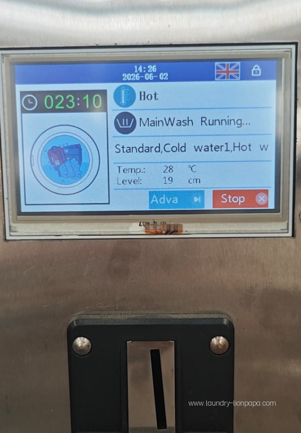 Close-up of the laundry machine programme interface and payment slot