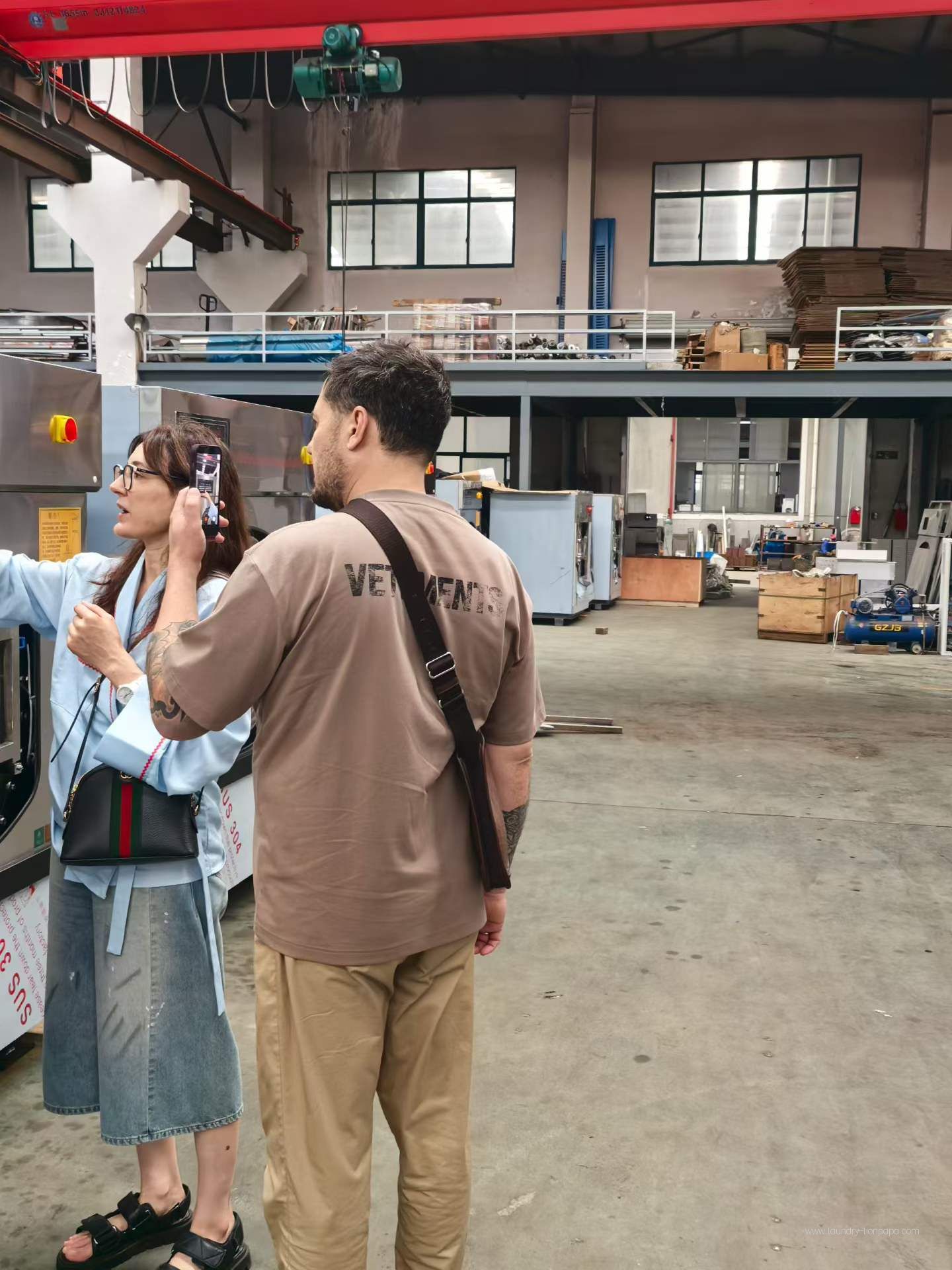 Visitors discussing laundry equipment in the factory