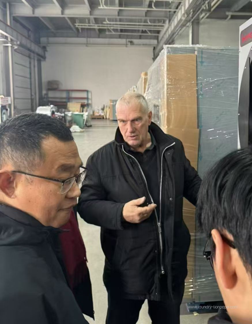 Factory discussion beside packaged laundry equipment